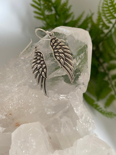 Silver angel wings ear rings on white background