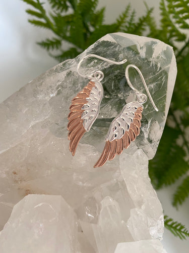 Silver and rose gold earrings on white background