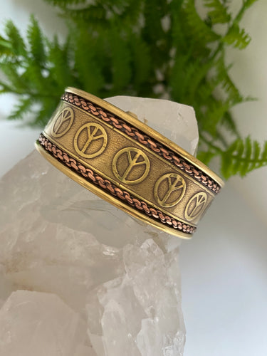 Brass and copper cuff on white background