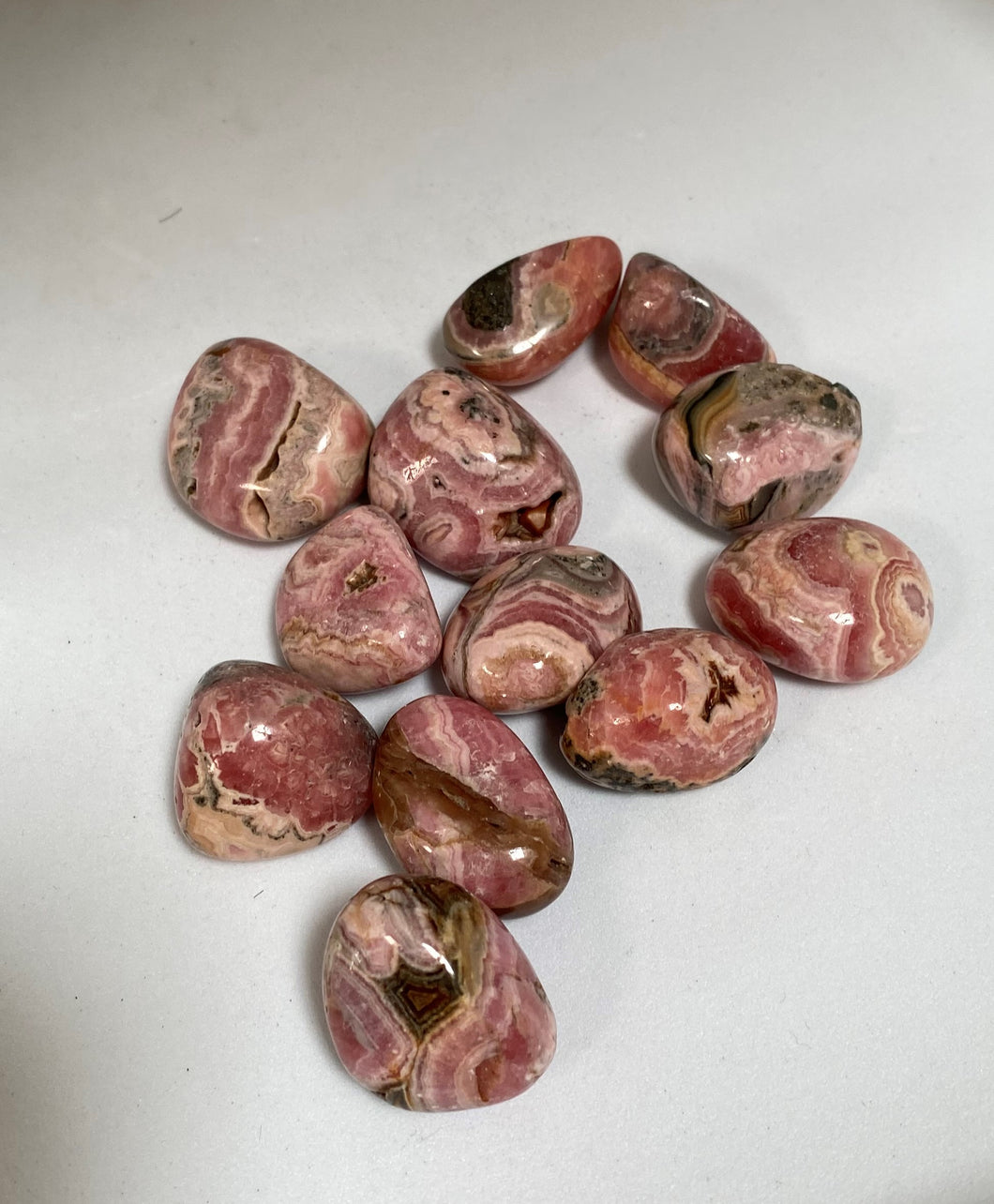 Rhodochrosite crystal tumble stones on white background