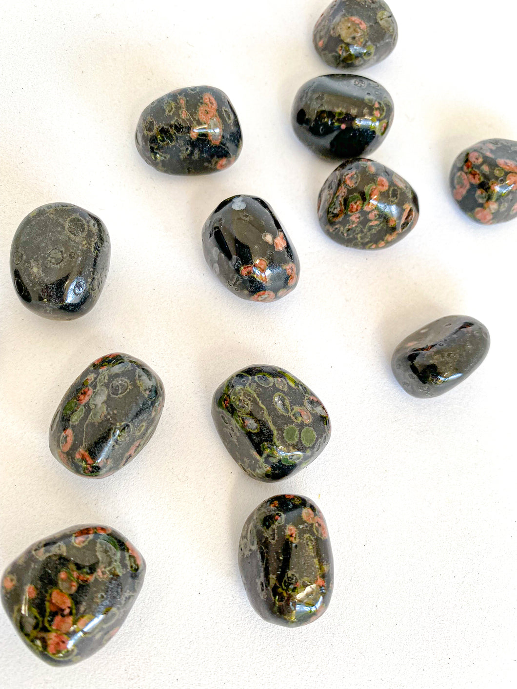 Snowflake Red Obsidian Tumble Stones on White Background